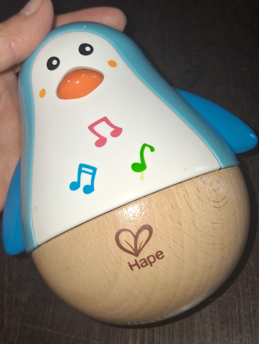 Hape Penguin Musical Wobbler, a wooden musical roly-poly toy with a tinkling bel